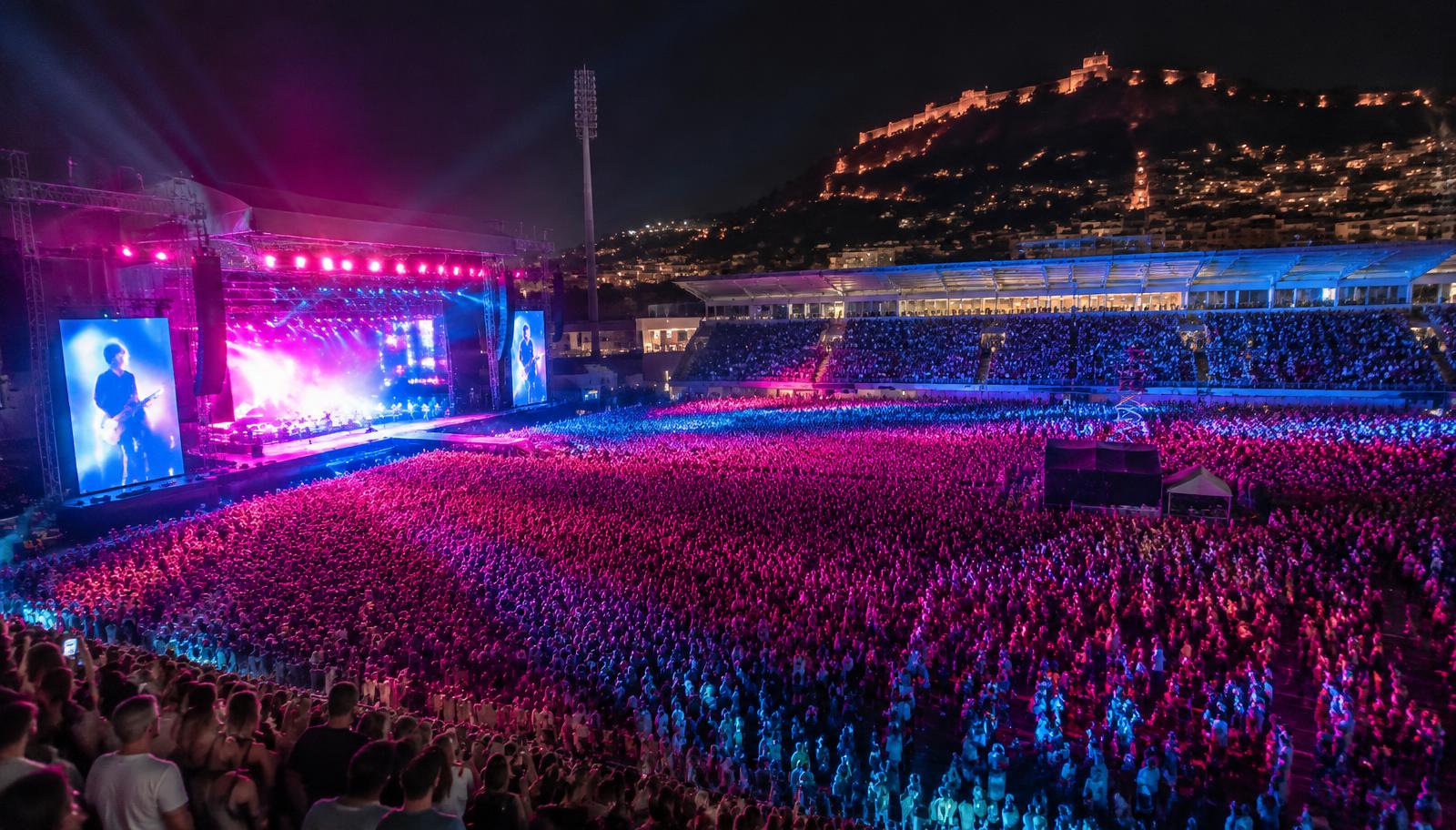 Gece ışıkları altında dolu bir stadyumda konser atmosferi
